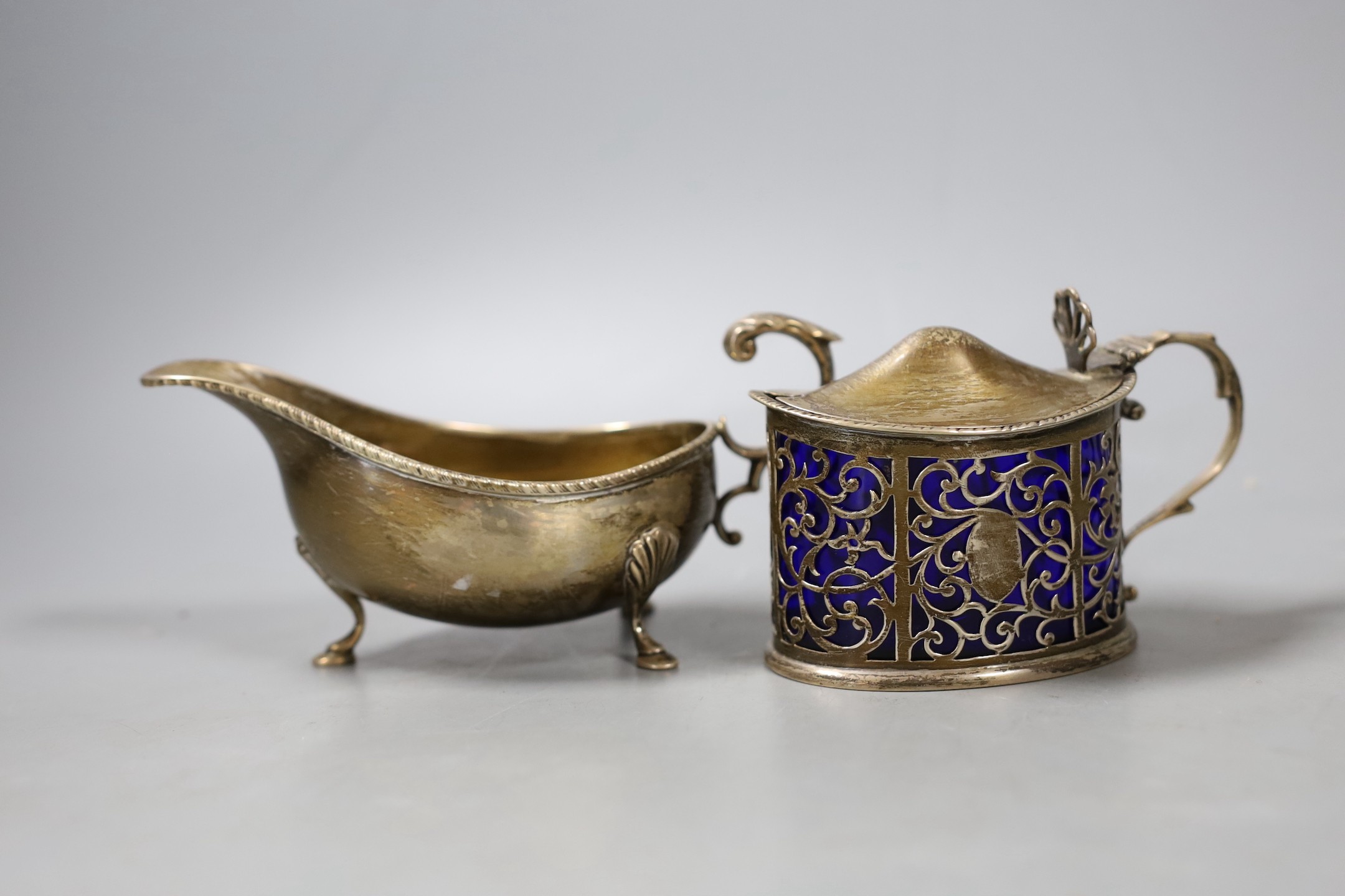 A late Victorian silver mustard, London, 1899 and a later silver sauceboat.